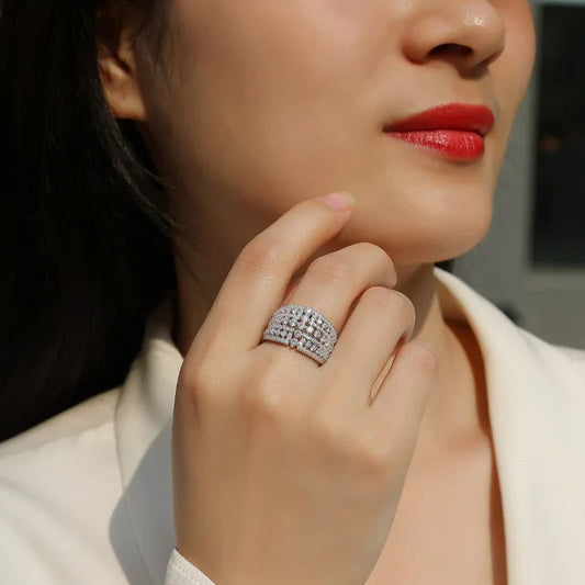 Silver-tone moissanite pavé engagement ring on finger, rounded cluster with center stone