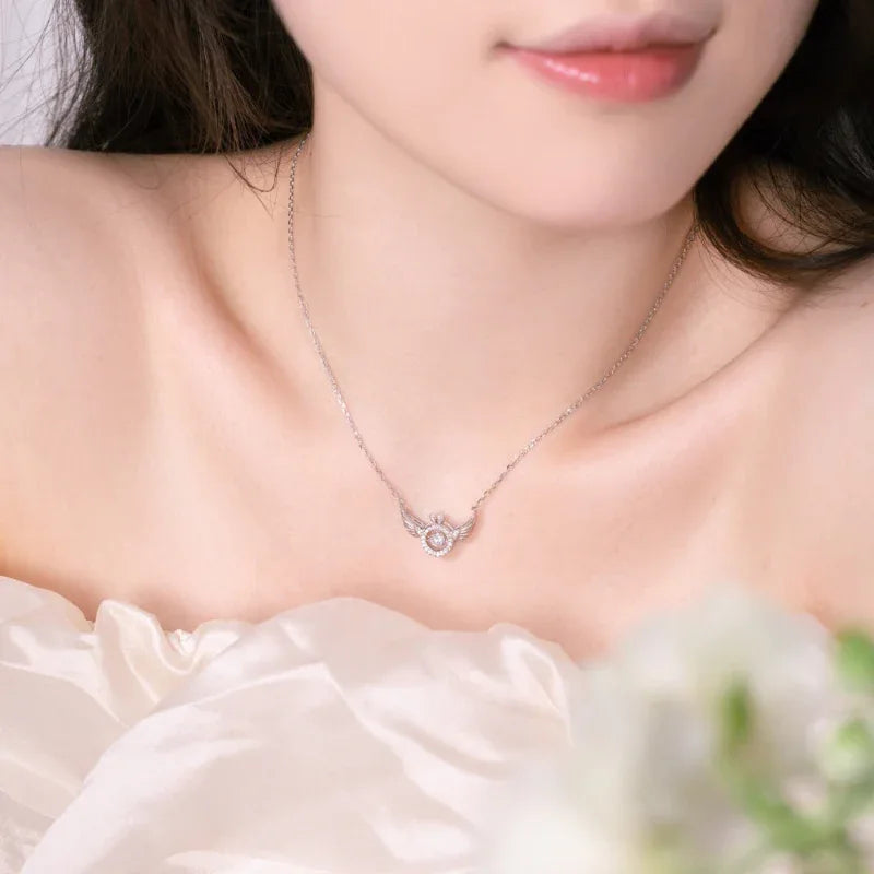 Silver-tone heart wings pendant necklace with round CZ center on model