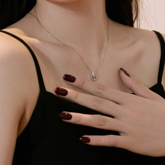 Silver teardrop CZ pendant necklace with matching earrings and ring on hand