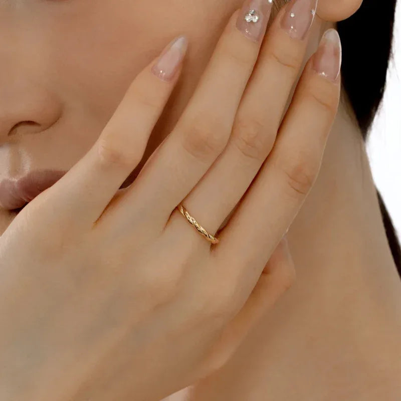Twisted rope ring in gold-tone metal on finger, braided texture band