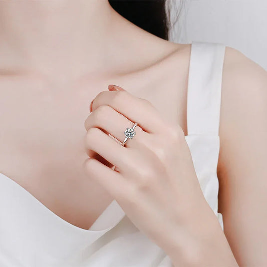 Moissanite engagement ring on hand, white gold band with round center and halo setting