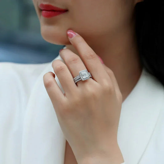Silver moissanite ring with emerald-cut center stone, pavé halo, and slim pavé band