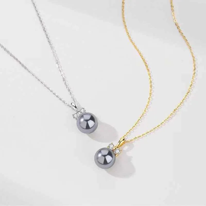 Layered pearl pendant necklaces in silver and gold tones with dark gray pearl beads
