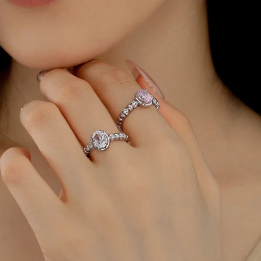 Sterling silver oval CZ eternity ring with white oval center stone and pavé halo band on finger