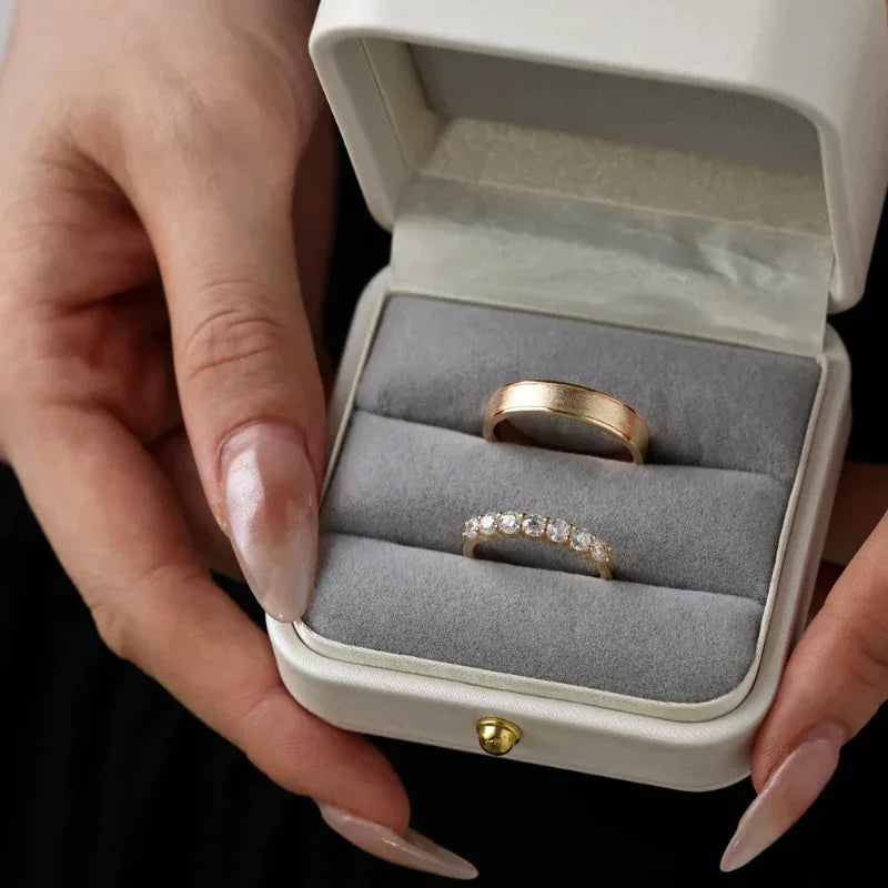 Champagne gold-tone ring set in a gift box: one smooth band and one CZ-accented band
