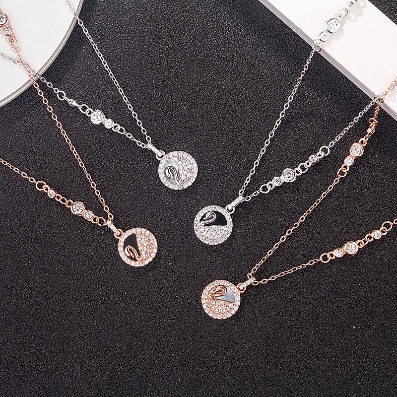 Round swan pendant necklaces with rose-gold and silver-tone chains, some with dark center stones