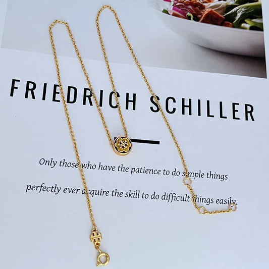 Gold-tone necklace set with round flower pendant, chain links, and lobster clasp