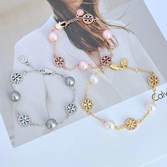 Rose gold pearl bracelet with round logo medallions and pink bead accents