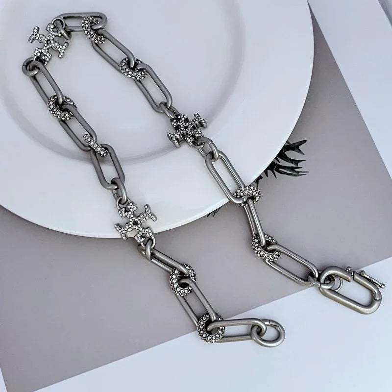 Rhinestone cross charm chain bracelet with oval links and lobster-style clasp, silver-tone