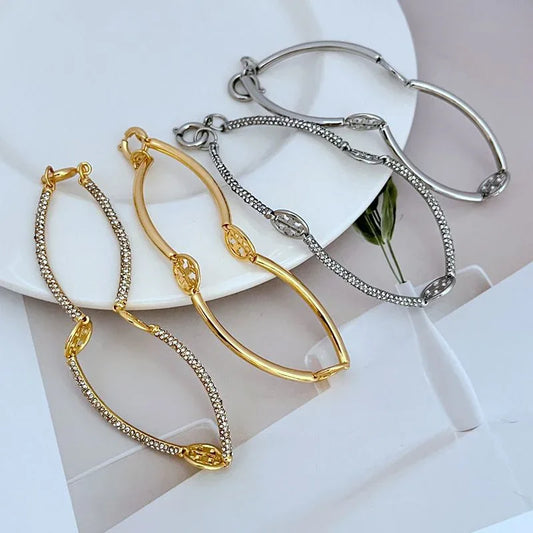Gold-tone and silver-tone bangle set with pavé logo and sparkle chain details