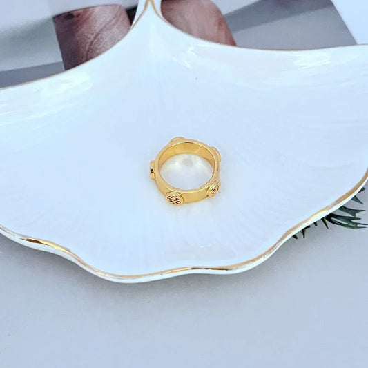 Gold metal hinge ring with engraved side detail and open center
