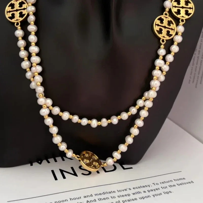 Pearl sweater necklace on mannequin: layered white pearls with gold-tone round medallion clasp