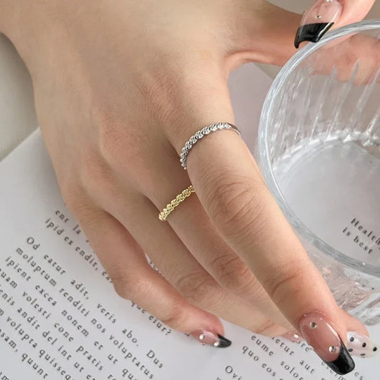 Silver twisted bead band ring on finger with small raised bead pattern
