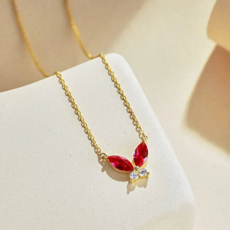 Gold-plated butterfly pendant necklace with red teardrop CZ stones and clear accents