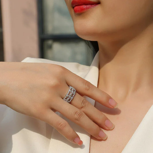 Silver moissanite ring on finger with round stone band in prong settings