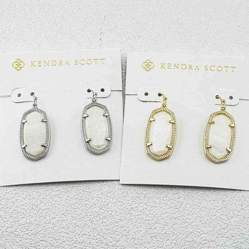 Geometric oval drop earrings with white stone centers, silver and gold-tone