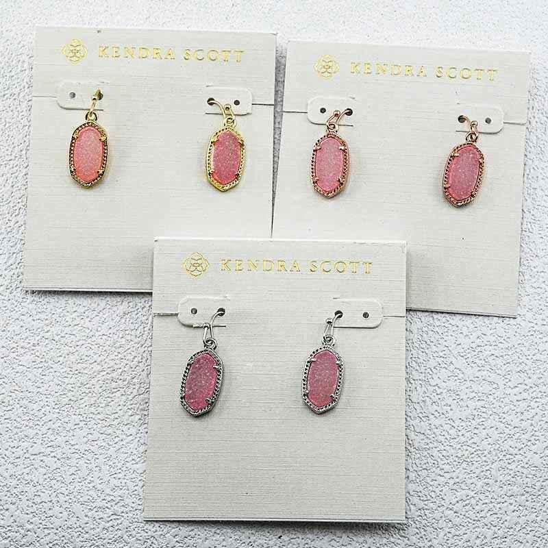 Pink teardrop earrings in gold, rose gold, and silver tones on display cards