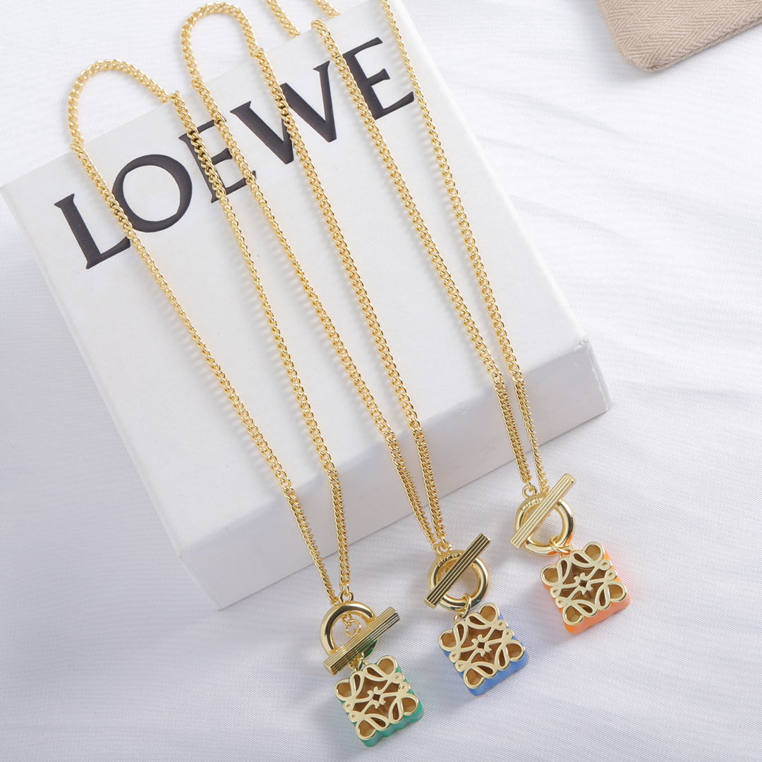 Gold-tone chain necklace with green and orange enamel square cutout logo pendants