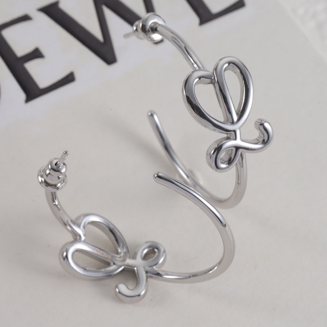 White gold C-shaped stud earrings close-up with interlocking logo motif and post