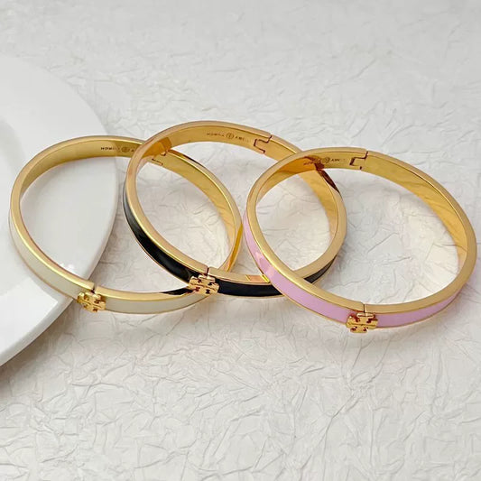 Tory Burch enamel metal bangles, set of white, pink, and black with gold logo