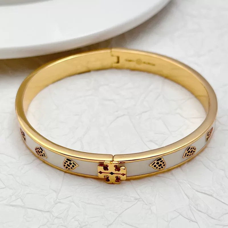 Gold-tone enamel bangle with paw prints and hinged center clasp