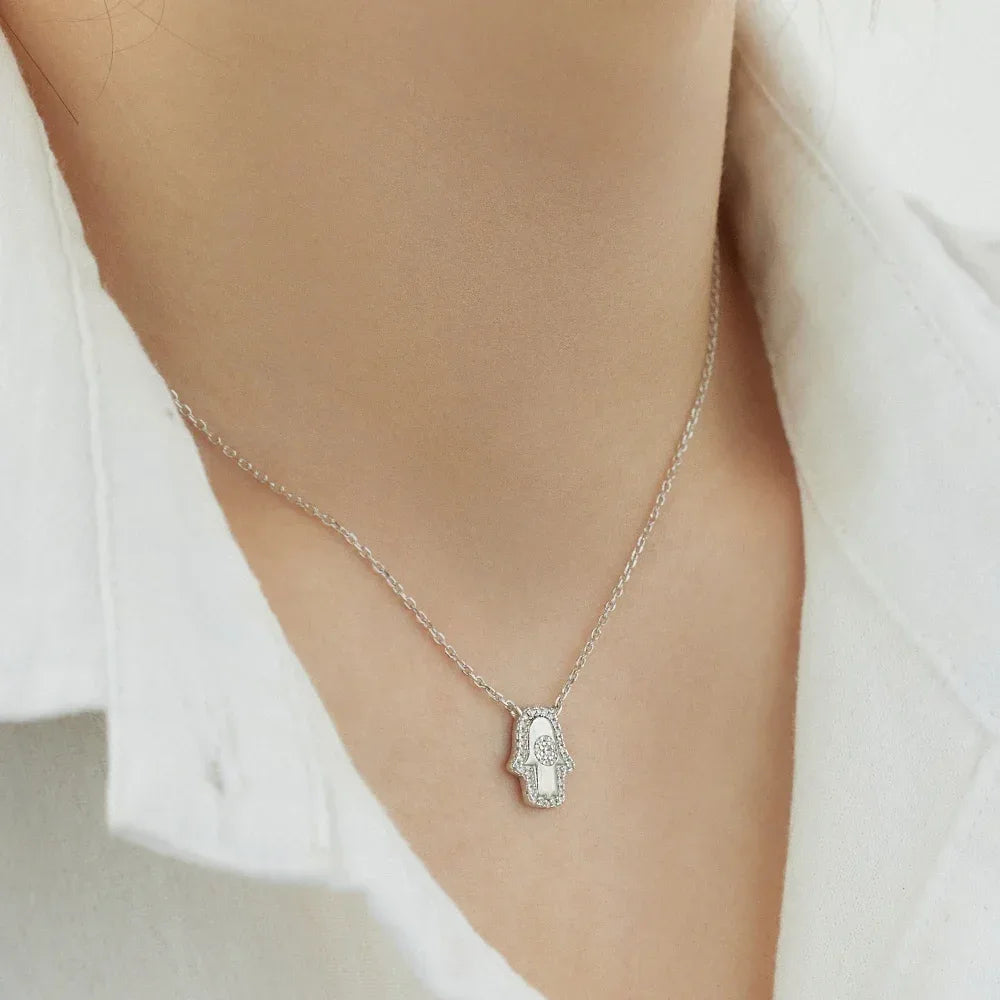 Silver hamsa hand evil eye pendant on chain necklace, close-up
