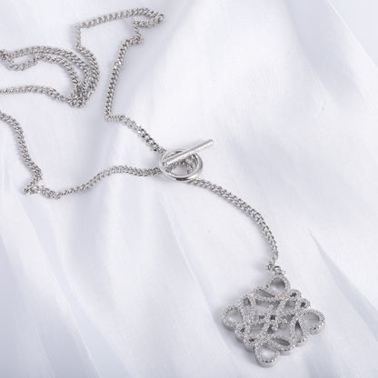 Silver chain necklace with square cutout logo pendant and O-ring clasp, close-up