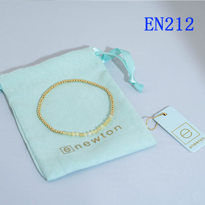 Round beaded elastic bracelet with gold-tone and light-yellow beads