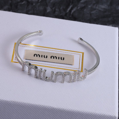 White-gold open bangle with diamond-studded zigzag row
