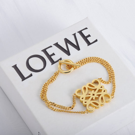 Gold chain bracelet with oval ring clasp and logo cutout pendant