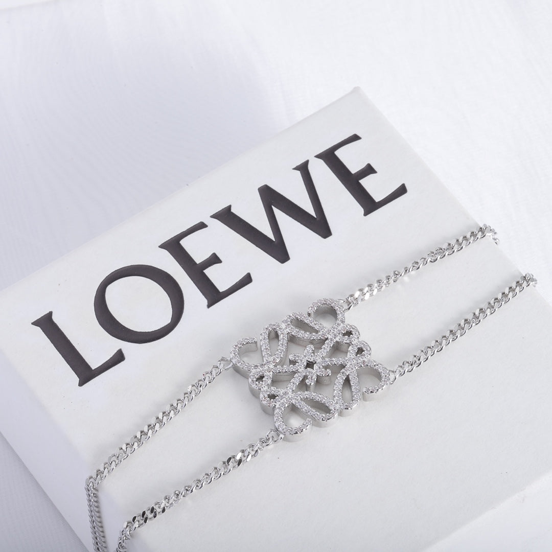 Silver openwork square metal bracelet with sculpted filigree centerpiece and chain links