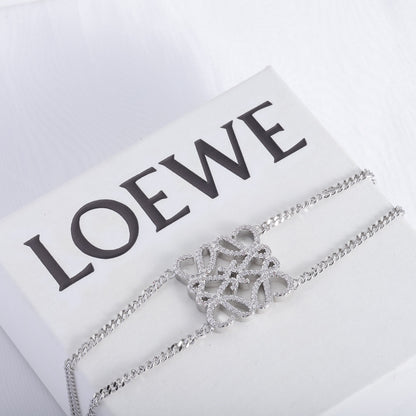 Silver openwork square metal bracelet with sculpted filigree centerpiece and chain links