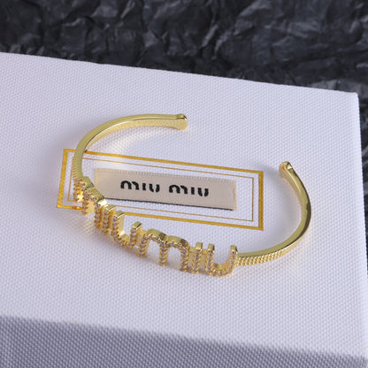 Gold open bangle with diamond-studded zigzag row