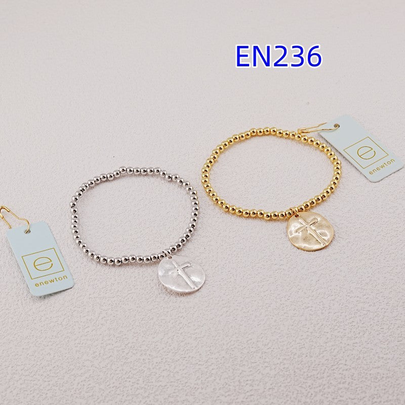 Pair of beaded cross charm bracelets, gold-tone and silver-tone, with oval pendants