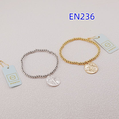 Pair of beaded cross charm bracelets, gold-tone and silver-tone, with oval pendants