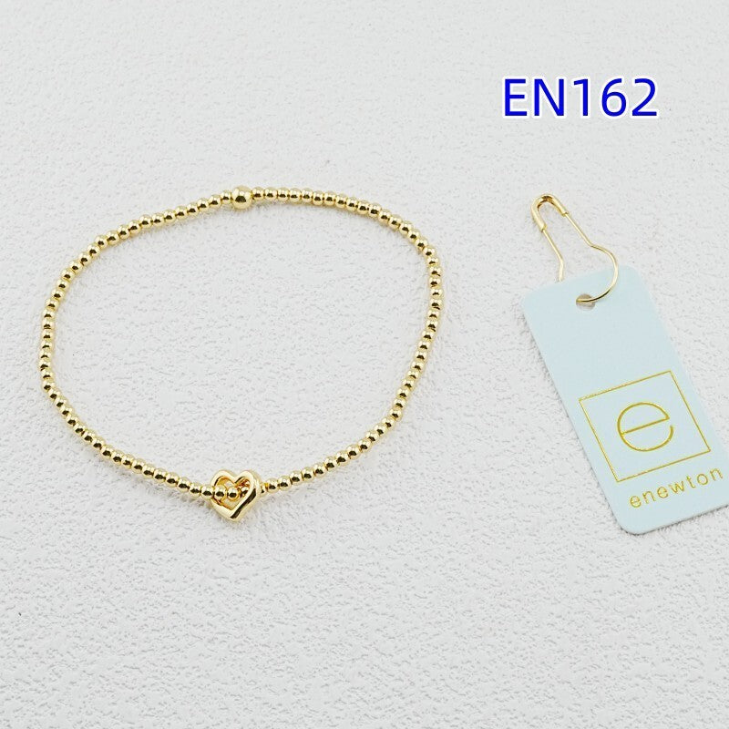 Gold heart-pendant beaded bracelet with central heart charm and clasp