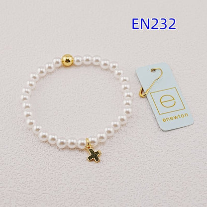 White pearl bead bracelet with gold accent bead and gold cross charm