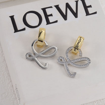 Silver logo stud earrings with openwork outline and gold hoop backing, clear stones