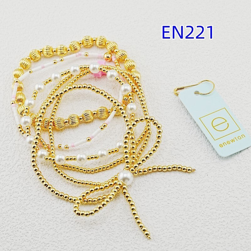 Gold-tone beaded bracelet set with faux pearls and pink accent bead details