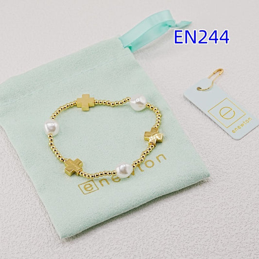 Gold cross-bead bracelet with pearl beads and small link accents