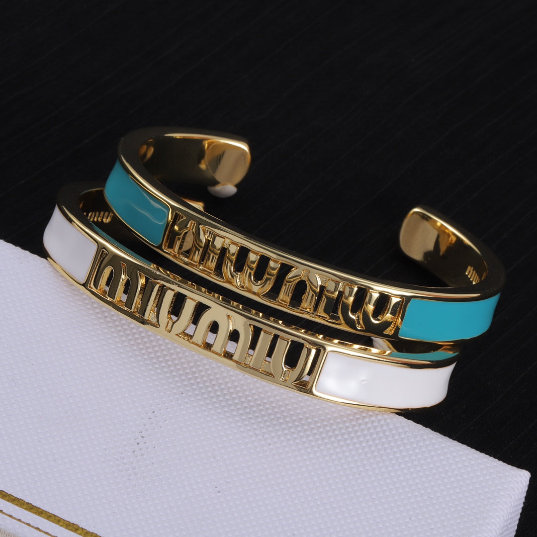 Enamel openwork logo bangles, gold-tone with white and teal enamel panels