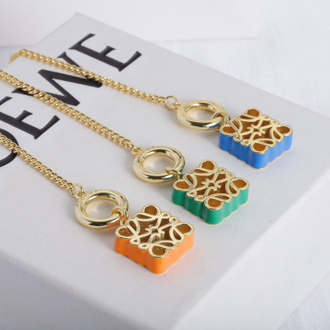 Gold-tone chain necklace with enamel square cutout logo charms in orange, green, and blue