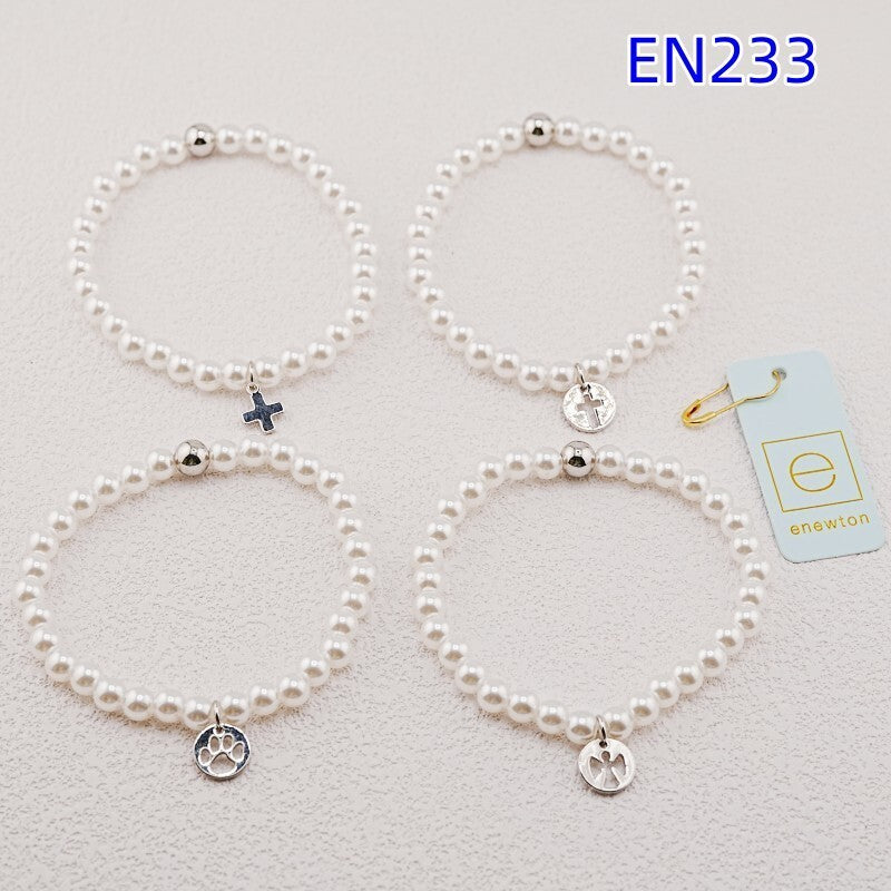 Set of four pearl strand bracelets with silver charms in paw, cross, and heart styles
