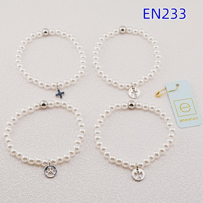 Set of four pearl strand bracelets with silver charms in paw, cross, and heart styles