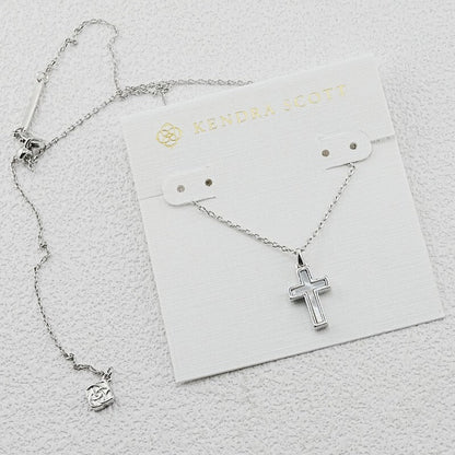 Silver cross pendant necklace with opal-like center and link chain