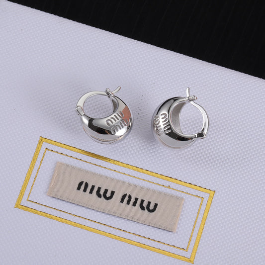 White gold hoop earrings, side view with 'miu miu' engraving
