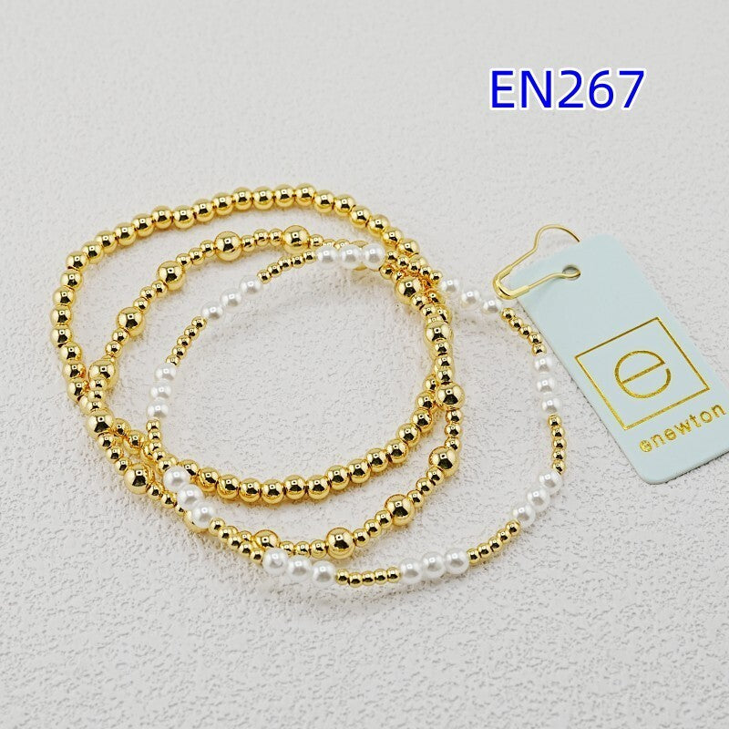 Three-piece bracelet set with gold bead strands and white pearl beads
