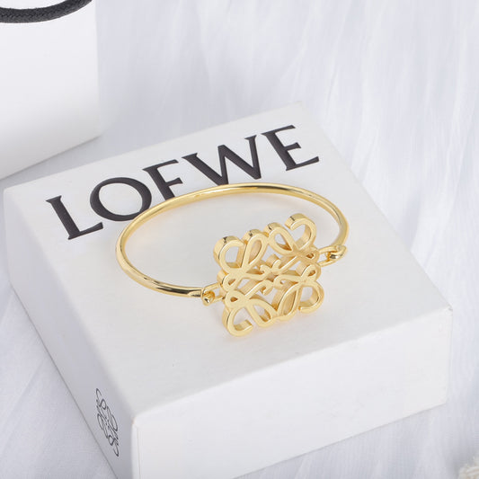 Polished gold open cuff bracelet featuring square cutout logo center
