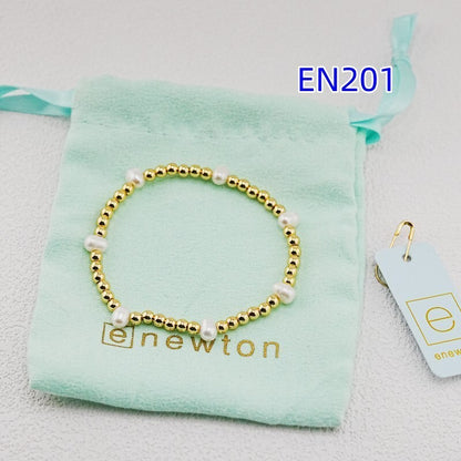 Gold beaded bracelet with white pearl accents and gold-tone bead links
