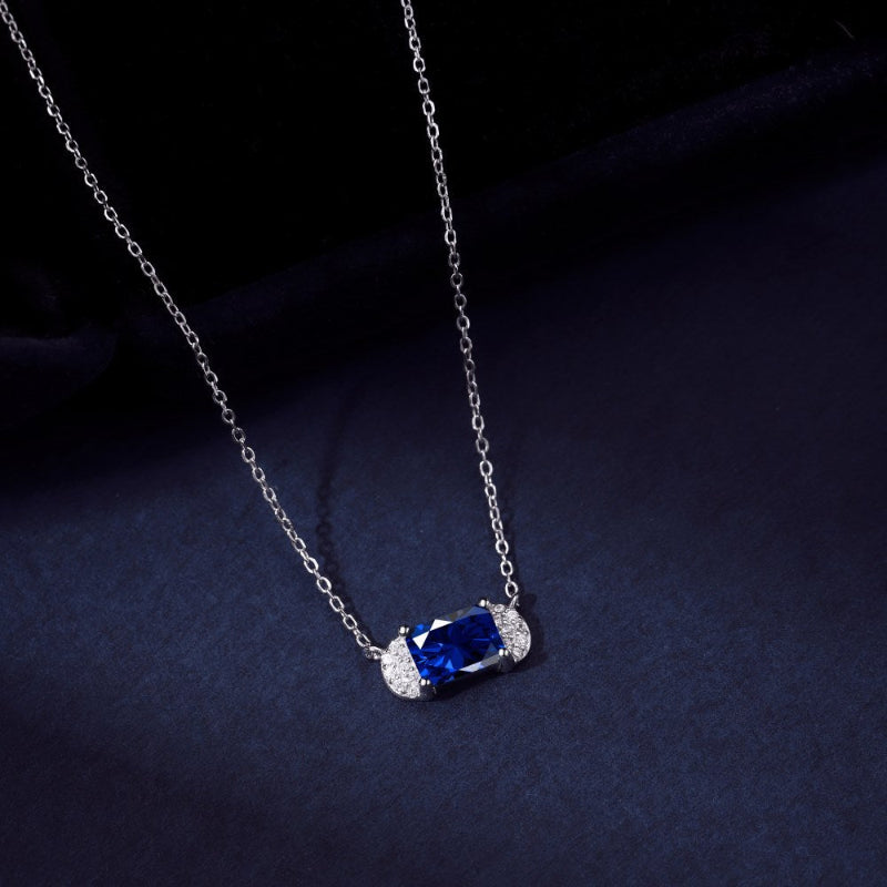 Shimmering Silver Station Necklace with Central Blue Gem and Winged Halos

